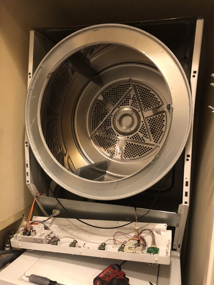 Dryer opened with drum exposed for repair